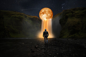 Wall Mural - photomontage with a man in front of a waterfall and a surreal moon