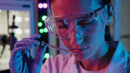 Poster - Laboratory technician carefully examines liquid in pipette, illuminated by vibrant pink and blue neon lights, creating a futuristic ambiance