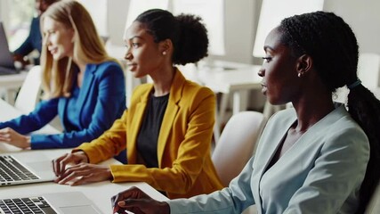 Poster - Multi ethnic businesswomen team collaborates on a project in a modern office, working together on laptops and desktop computers in slow motion