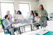 © deagreez - Group of cheerful business professionals collaborating in a bright modern office setting, multi-age