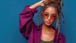 © Konstiantyn Zap - Trendy young hispanic female with sunglasses and casual purple shirt on blue background