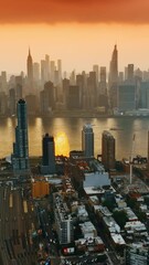 Wall Mural - Amazing orange sky at sunset over the great New York city. Panorama with skyscrapers divided by the river. Top view.