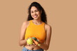 © Pixel-Shot - Young African-American woman with fresh fruits and vegetables on beige background. Independence from Meat Day