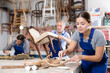 © JackF - Portrait of skillful repair woman carpenter renovating chair furniture using tools in woodwork studio