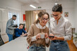 © Miljan Živković - two female colleagues on the coffee break use mobile phone at office