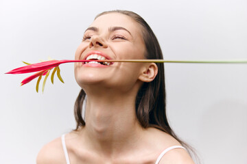 Canvas Print - Happy young woman with flower smiling joyfully, creating a vibrant atmosphere and fresh mood. Seasonal and stylish composition celebrating beauty and joy.