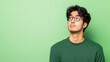 © Dream Vision - Job Interview Atmosphere Concept, Thoughtful man in green sweater looking up against green background