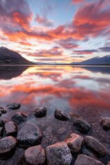 Wall Mural - serene sunset over calm lake with rocky shoreline