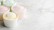 © pinporn manosri - Frozen ice cream tubs with frost-covered lids, arranged on a white marble background with a spacious copy space.