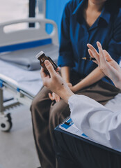 Wall Mural - doctor consulting senior old patient filling form at consultation. Professional physician wearing white coat talking to mature woman signing medical paper at appointment visit in clinic.