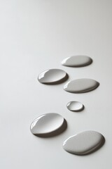 Aufkleber - Liquid drops flowing on white surface, background blurred