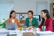 © amnaj - Asian businesswomen working together analyzing financial charts in modern office