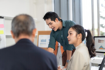 Wall Mural - asian manager explaining project to colleagues during office meeting