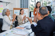 © amnaj - Business team clapping hands during a meeting in the office