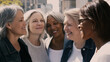 © Andrei Burakov - Group of four cheerful mature multi ethnic female colleagues enjoying a moment of complicity and genuine happiness together during a work break in the city celebrating International Women's Day