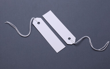 Wall Mural - White paper tags on strings on dark gray background