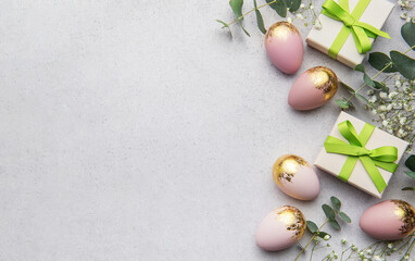 Wall Mural - Easter eggs and gift boxes decorated with eucalyptus leaves on concrete background