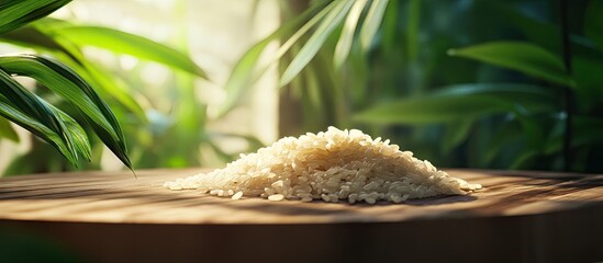 Poster - Wooden tabletop with a pile of wineji rice highlighted by natural sunlight and vibrant green leaves in the background enhancing the culinary atmosphere
