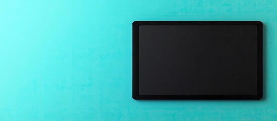 Leinwandbilder - Minimalistic black graphic tablet positioned on a sleek black surface against a vibrant blue background in a clean flatlay composition