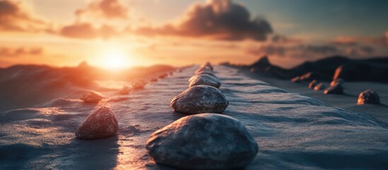 Aufkleber - Stones marking a path at sunrise with a warm orange glow illuminating the landscape creating a sense of progress and achievement in nature