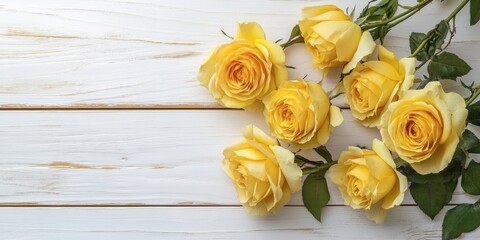 Sticker - Bright yellow roses arranged artistically on a textured white wooden surface with greenery accents in an overhead view providing ample space for text.