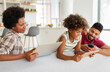 © NDABCREATIVITY - Obsessed to tech devices happy african american family using digital tablet, computer, smartphones