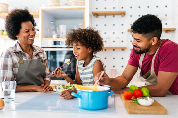 Wall Mural - happy african american family preparing healthy food in kitchen, having fun together on weekend