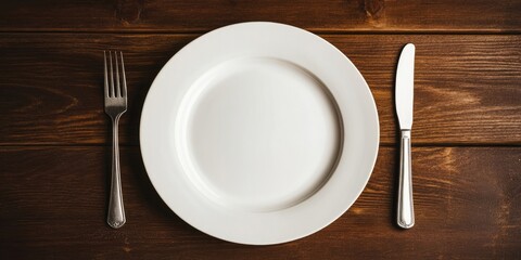 Aufkleber - Minimalist setting featuring a white dinner plate centered on a wooden table, accompanied by a silver fork on the left and a silver knife on the right.