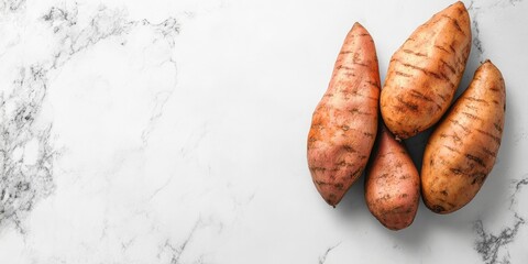 Poster - Sweet potatoes arranged on a clean white marble surface with space on the left, showcasing their textured skin and natural earthy tones.