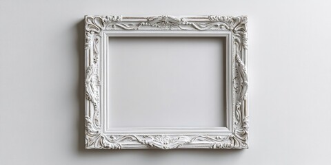 Fototapete - Elegant ornate white picture frame with intricate designs centered against a soft gray wall, creating a classic and timeless aesthetic.