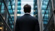 © InspirationDesign - Businessman from behind looking at modern architecture. Ideal for corporate vision, business ambition, and urban success