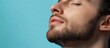 © pngking - Close-up portrait of a relaxed young man with a beard against a light blue background displaying calm expression and copy space
