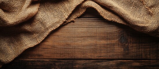 Aufkleber - Textured burlap fabric draped on rustic wooden surface creating a natural and earthy background ideal for design projects