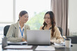 © mojo_cp - Asian office employee supervising Mentor training trainee at office.