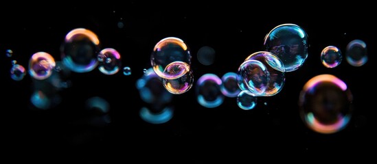 Poster - Colorful soap bubbles floating in dark water with soft reflections and highlights creating a serene and magical atmosphere