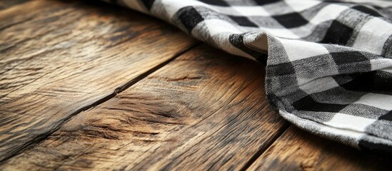 Poster - Checkered kitchen napkin draped on rustic brown wooden table surface for culinary or home decor themes.