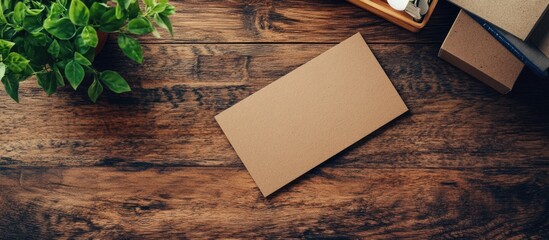 Poster - Blank business card on rustic wooden background with greenery and stationery items for corporate branding mockup and creative design space.