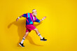 © deagreez - Full length photo of cheerful positive mature guy dressed retro sport jacket running emtpy space isolated yellow color background