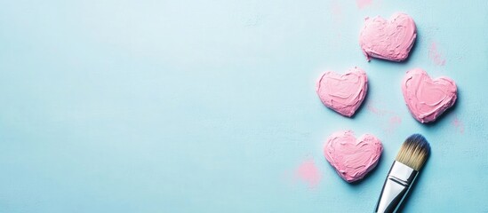 Poster - Decorative Pink Heart Shapes on Light Blue Surface with Paintbrush and Blank Space for Creative Text or Messaging