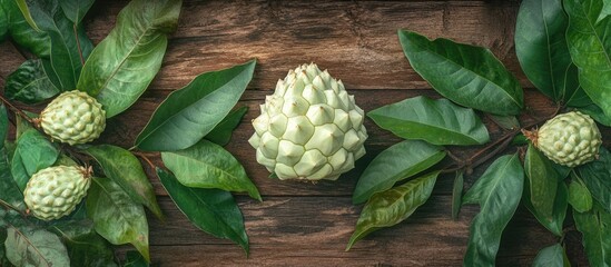 Poster - Tropical custard apple surrounded by green leaves on a rustic wooden background showcasing its unique texture and delicious flavor