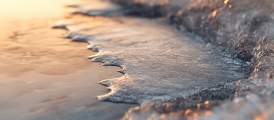 Wall Mural - Detail of frozen water puddle edge showing intricate crystallization patterns and cracks illuminated by soft warm light