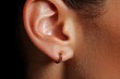 © Balaraw - Close-up of an ear with a gold hoop earring.