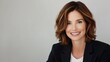 © sweet_mellow - Smiling middle-aged woman with brown hair in formal attire against neutral background