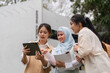 © wichayada - Diverse female students collaborating on a tablet, sharing ideas and notes.