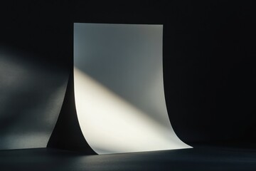 Poster - Beautiful blank sheet of paper illuminated by dramatic lighting against a deep black background creating an artistic effect