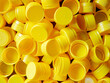 © NARONG - yellow plastic bottle caps.Recycling collection and production processing plastic bottle caps background ,Industrial production of bottle caps made of yellow high-density polyethylene.