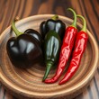 © Daniel Rabadán - Black and red chili peppers on wooden plate / Chiles negros y rojos sobre plato de madera