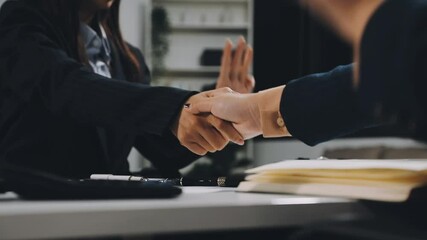 Poster - Entrepreneurs collaboration deal shaking hands in a modern office and financial paper graph on desk.