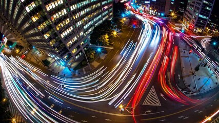 Poster - Busy city street captured at night with vibrant light trails and urban architecture