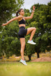 © Dewald - Young female athlete in black sportswear exercising outdoors in a scenic rural setting. Captured in various poses including stretching, jumping, and smiling, showcasing fitness, health.